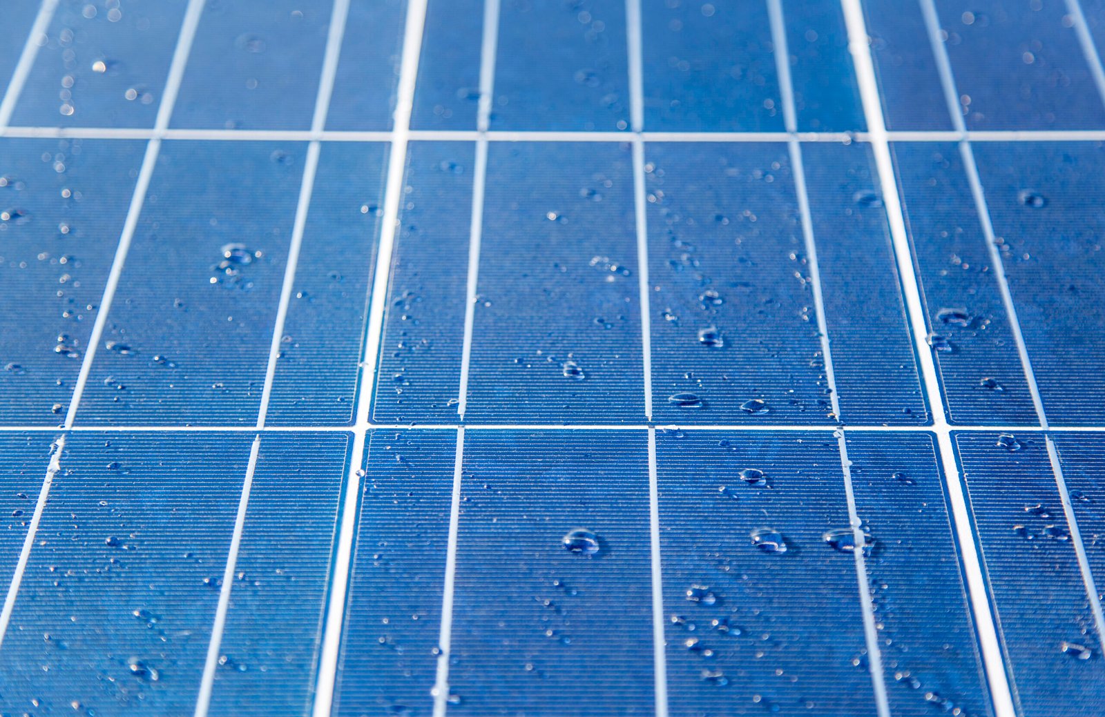 Regen fällt auf Solarmodule eines Hausdachs